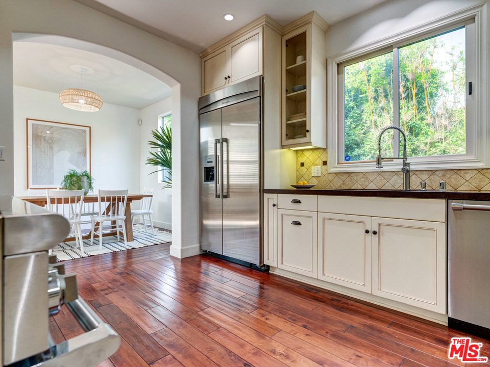 2031 Walnut Avenue Venice, CA 90291 - Photo 7 of 29 a kitchen with stainless steel appliances granite countertop wooden floors and white cabinets