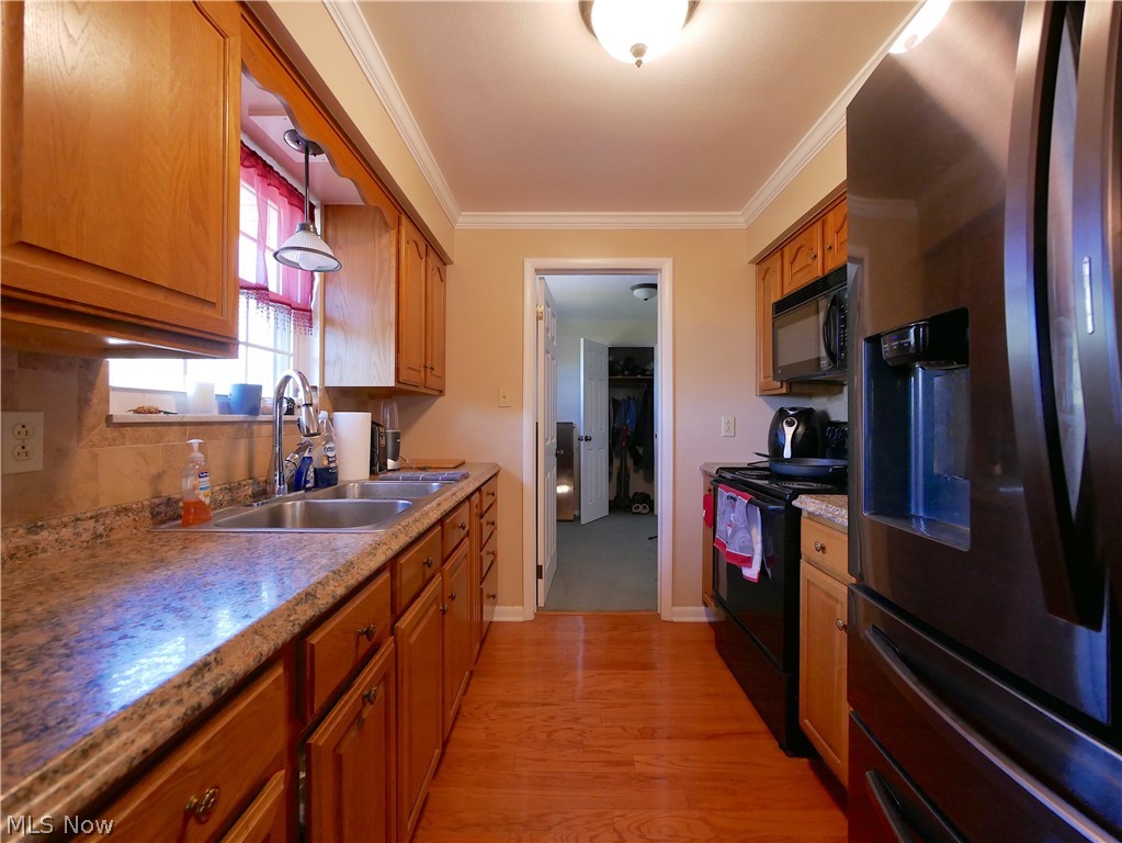 173 Patterson Road Weirton, WV 26062 - Photo 12 of 31 Kitchen featuring backsplash, crown molding, black appliances, sink, and light wood-type flooring