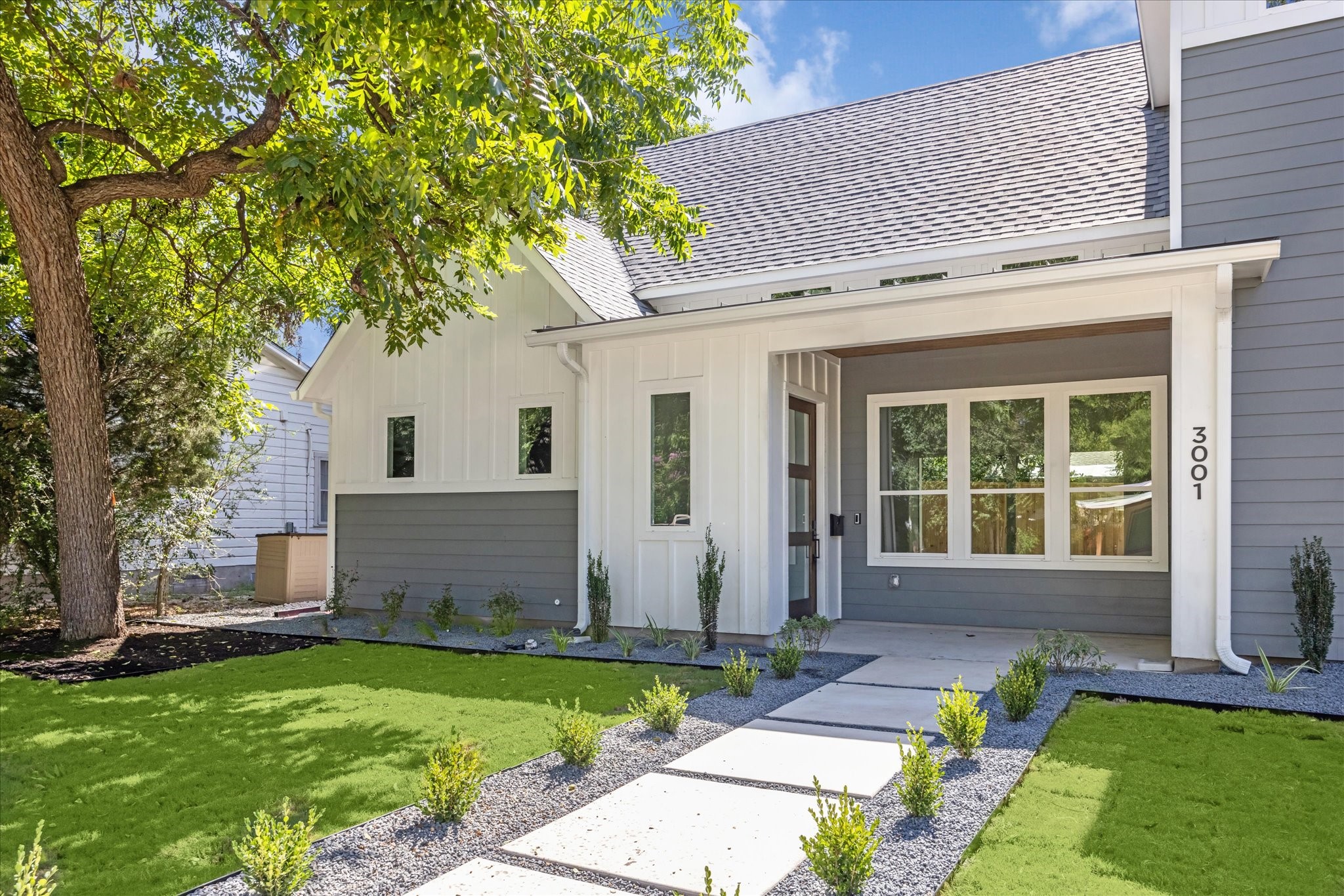a front view of a house with a garden and yard