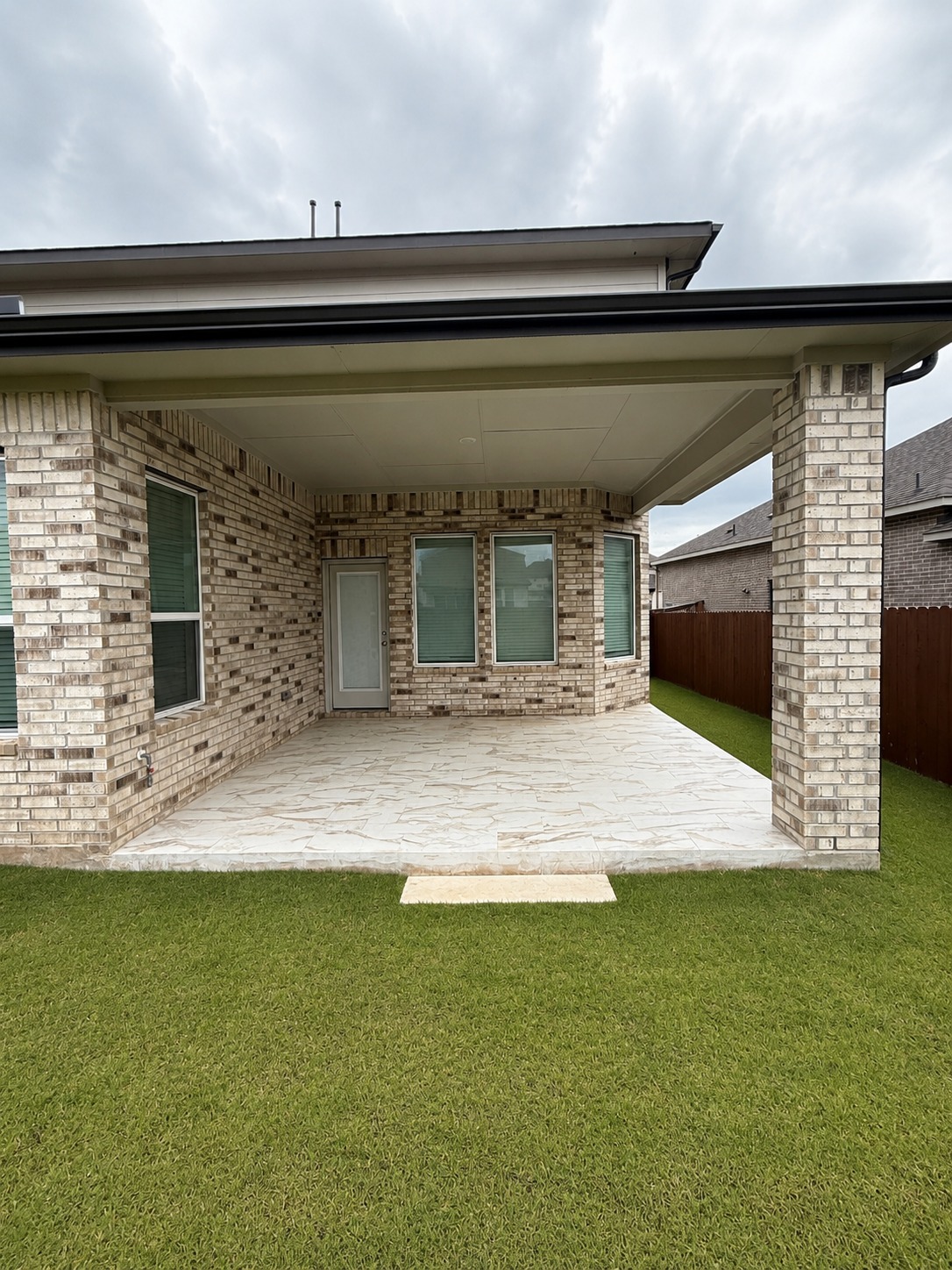 1213 Bryson Rdg Trail Leander, TX 78641 - Photo 15 of 16 An inviting covered patio extends to a manicured lawn, perfect for outdoor enjoyment.