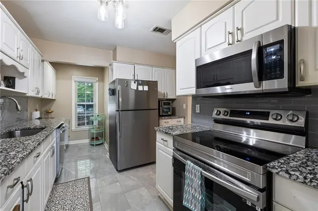 a kitchen with a refrigerator stove and microwave