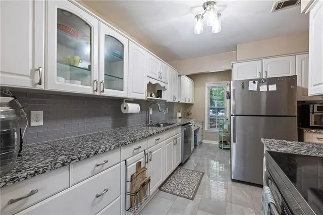 a kitchen with stainless steel appliances granite countertop a sink stove and refrigerator