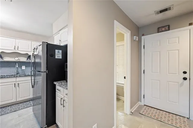 a view of a kitchen with refrigerator and wooden cabinets
