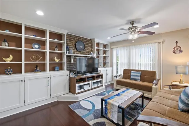 a living room with furniture a flat screen tv and a window
