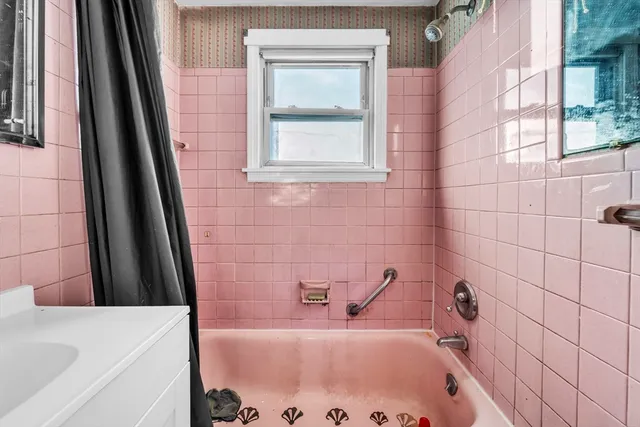 a bathroom with a tub a sink and a window