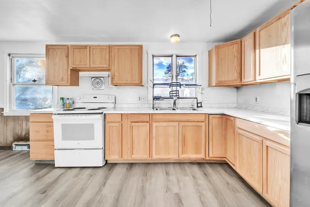 a kitchen with kitchen island granite countertop white cabinets and white appliances