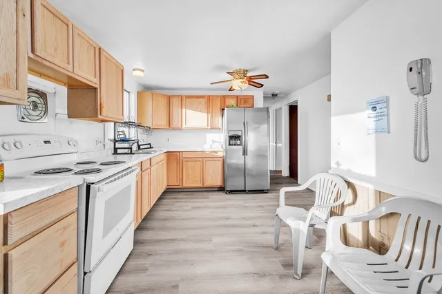 a large kitchen with stainless steel appliances kitchen island granite countertop a refrigerator and a stove top oven