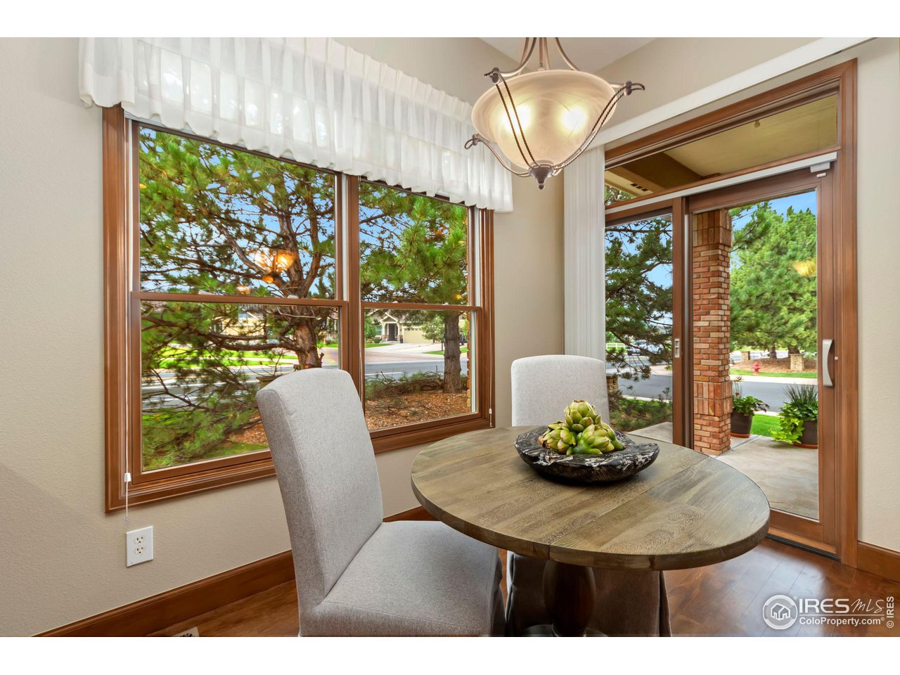 8209 Spinnaker Bay Drive Windsor, CO 80528 - Photo 13 of 26 a dining room with furniture large windows and a chandelier