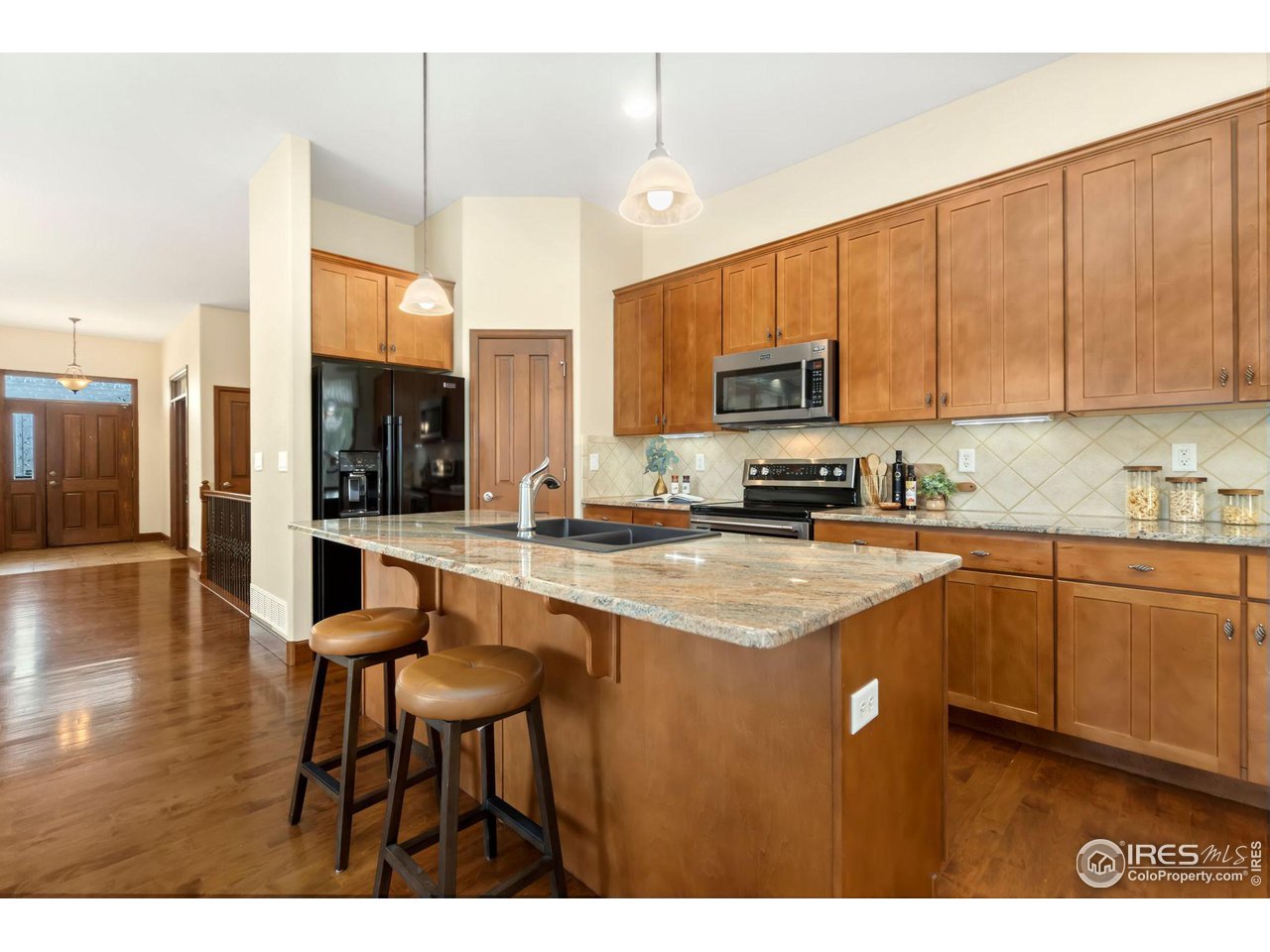 8209 Spinnaker Bay Drive Windsor, CO 80528 - Photo 8 of 26 a kitchen with stainless steel appliances granite countertop a stove a sink dishwasher and a refrigerator with wooden floor