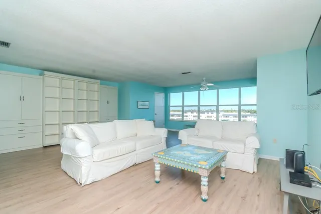 an empty room with wooden floor cabinet and windows