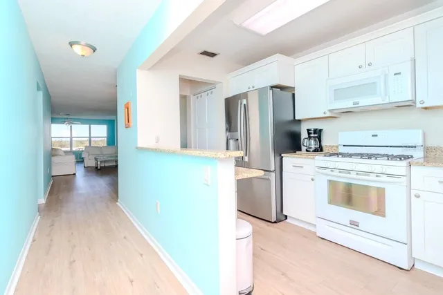 a kitchen with granite countertop stainless steel appliances a sink stove and cabinets