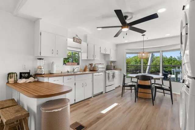 a kitchen with a table chairs stove and wooden floor