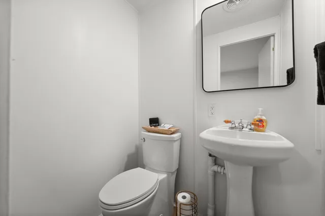 a bathroom with a toilet sink and mirror