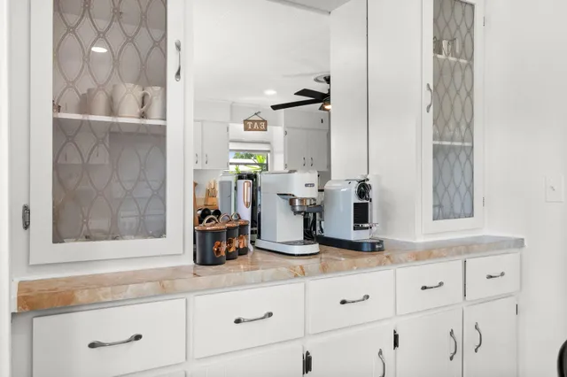 a kitchen with white cabinets and sink
