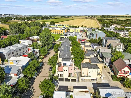 an aerial view of residential houses with outdoor space and ocean view