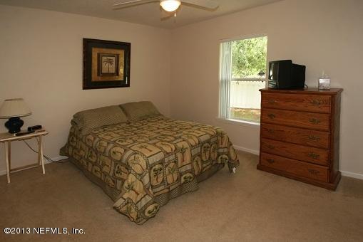 1825 Keswick Road St. Augustine, FL 32084 - Photo 18 of 19 a bedroom with a bed and a flat tv screen on dresser