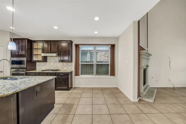 a large kitchen with a stove a sink dishwasher and a refrigerator