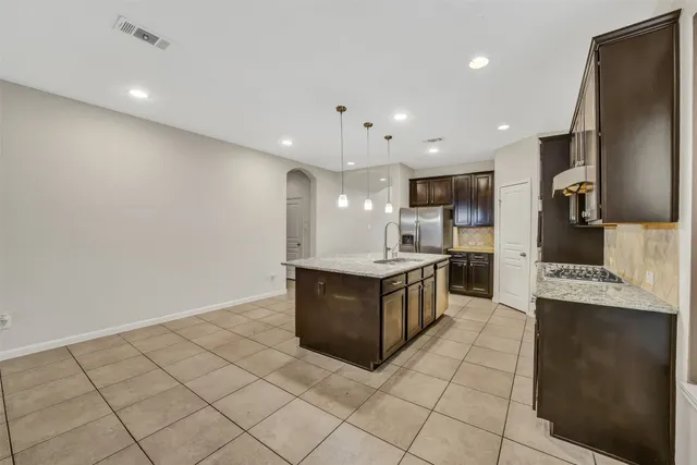 a large kitchen with a large counter top and stainless steel appliances