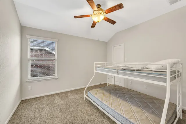 a bedroom with a bed and a ceiling fan