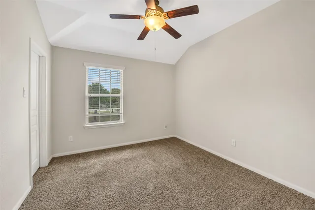 an empty room with closet and a chandelier fan