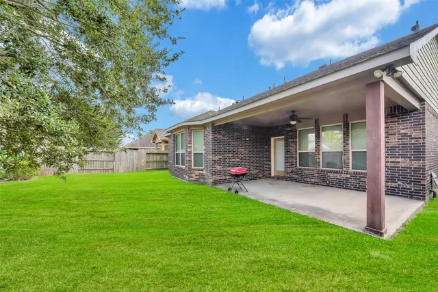 a view of a chair and table in backyard of the house