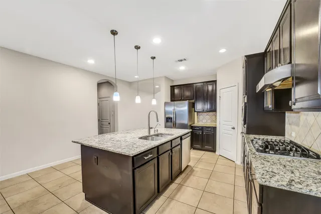a kitchen with stainless steel appliances granite countertop a stove oven and a refrigerator