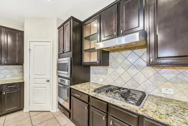 a kitchen with stainless steel appliances granite countertop a refrigerator and a stove top oven