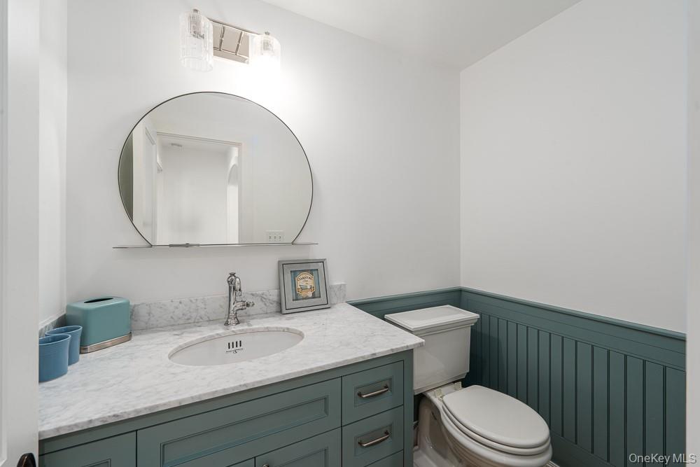 19000 Main Road Mattituck, NY 11952 - Photo 15 of 32 Half bath with a wainscoted wall, toilet, and vanity