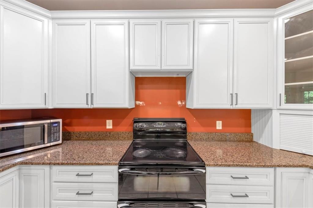 231 Beaver Ridge Road Jasper, GA 30143 - Photo 28 of 80 a kitchen with granite countertop white cabinets and stainless steel appliances