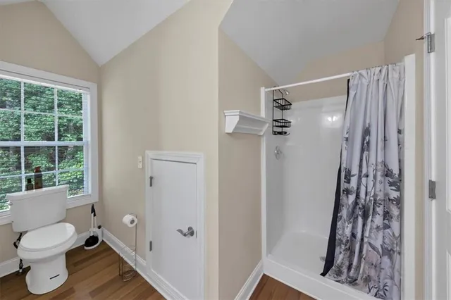 a front view of a house with a garden and trees