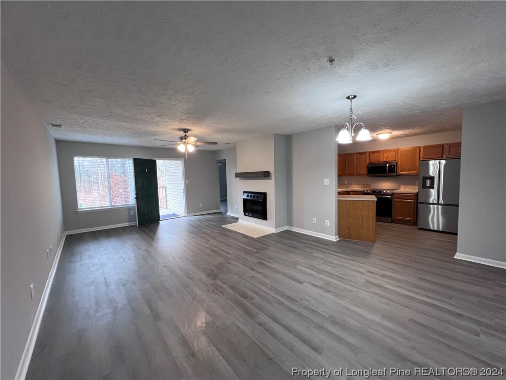 3375 Galleria Drive, Unit 17 Fayetteville, NC 28303 - Photo 3 of 19 an empty room with wooden floor kitchen view and a kitchen