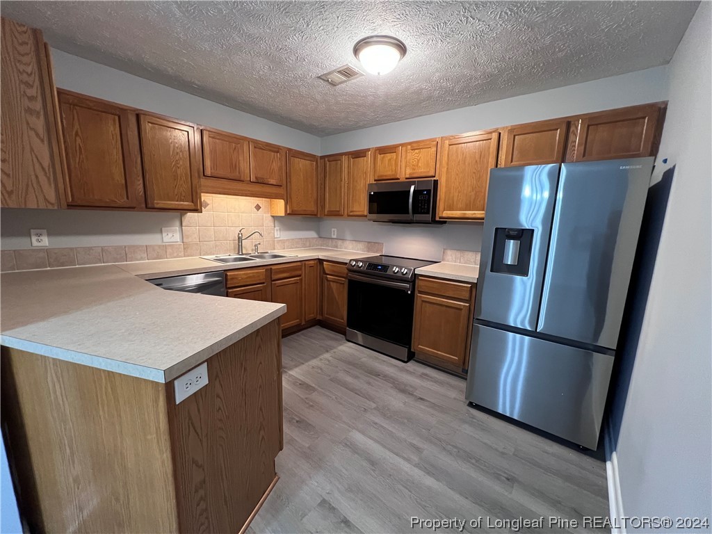 3375 Galleria Drive, Unit 17 Fayetteville, NC 28303 - Photo 7 of 19 a kitchen with stainless steel appliances granite countertop a refrigerator a sink dishwasher a stove and white countertops with wooden floor