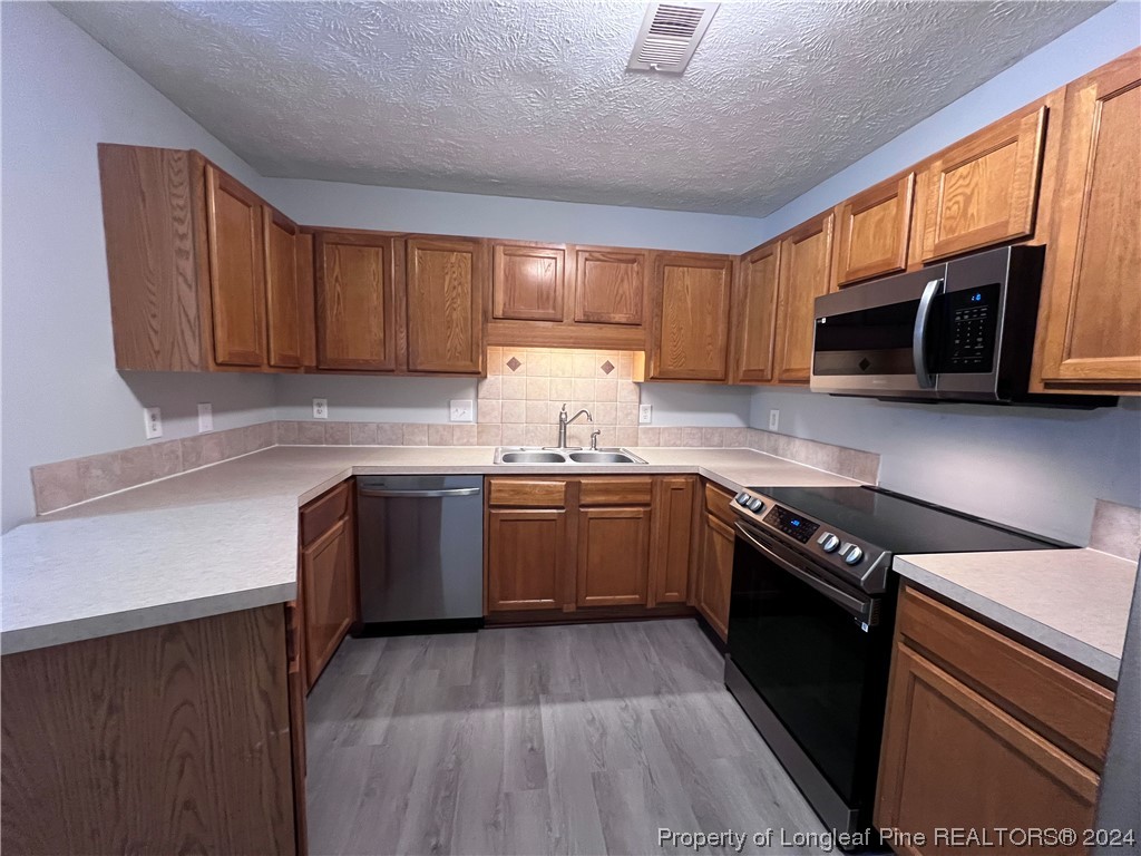 3375 Galleria Drive, Unit 17 Fayetteville, NC 28303 - Photo 8 of 19 a kitchen with stainless steel appliances granite countertop wooden cabinets a stove top oven a sink and dishwasher