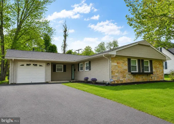 a front view of a house with a garden and yard