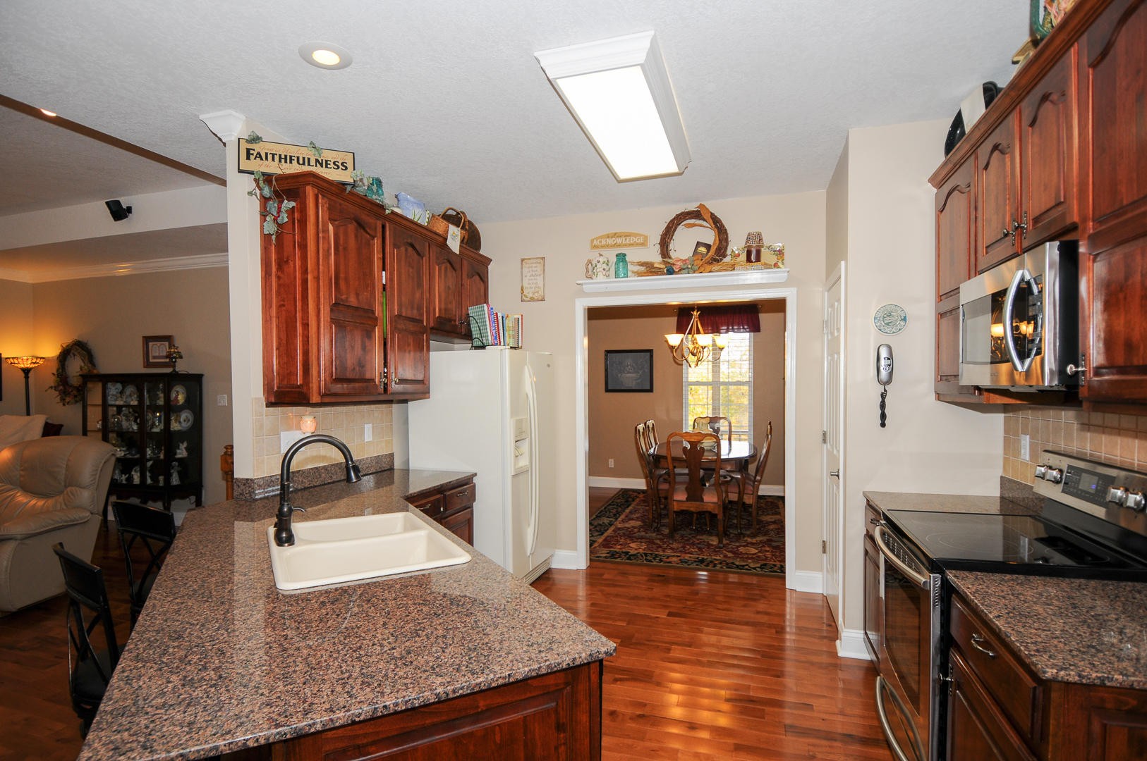 5656 North Trigonia Road Greenback, TN 37742 - Photo 7 of 40 a kitchen with granite countertop a stove a sink and a wooden cabinets