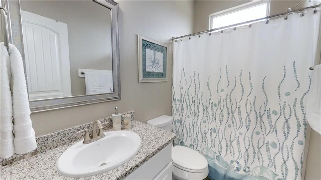 14916 Packery View Loop Corpus Christi, TX 78418 - Photo 14 of 32 a bathroom with a toilet a sink and a mirror