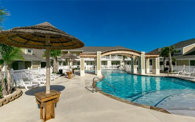 a view of a house with swimming pool and sitting area