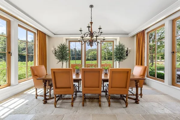 a dining room with furniture large windows and wooden floor