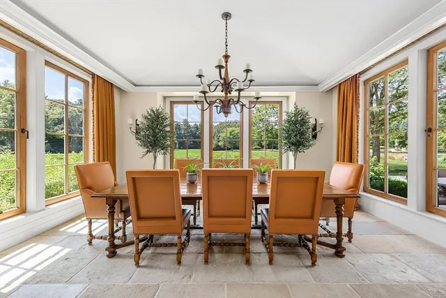 a dining room with furniture large windows and wooden floor