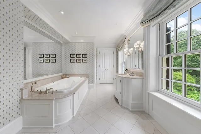 a spacious bathroom with a tub sink and mirror