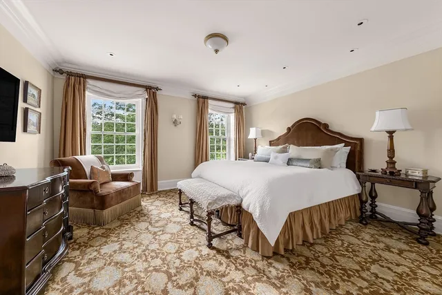 a bedroom with a bed and a dresser next to a window