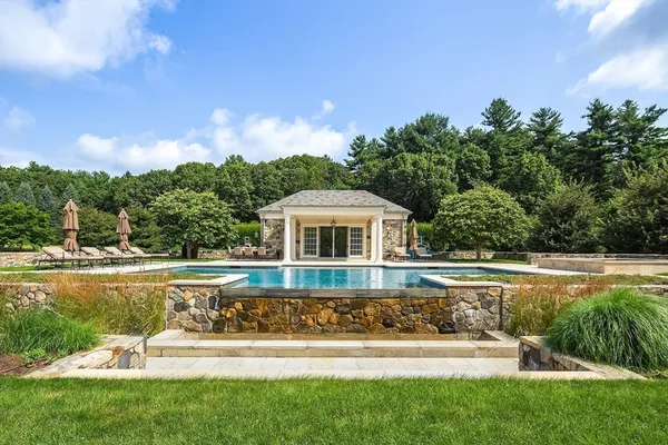 a front view of a house with swimming pool having outdoor seating