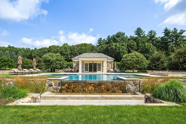 a front view of a house with swimming pool having outdoor seating