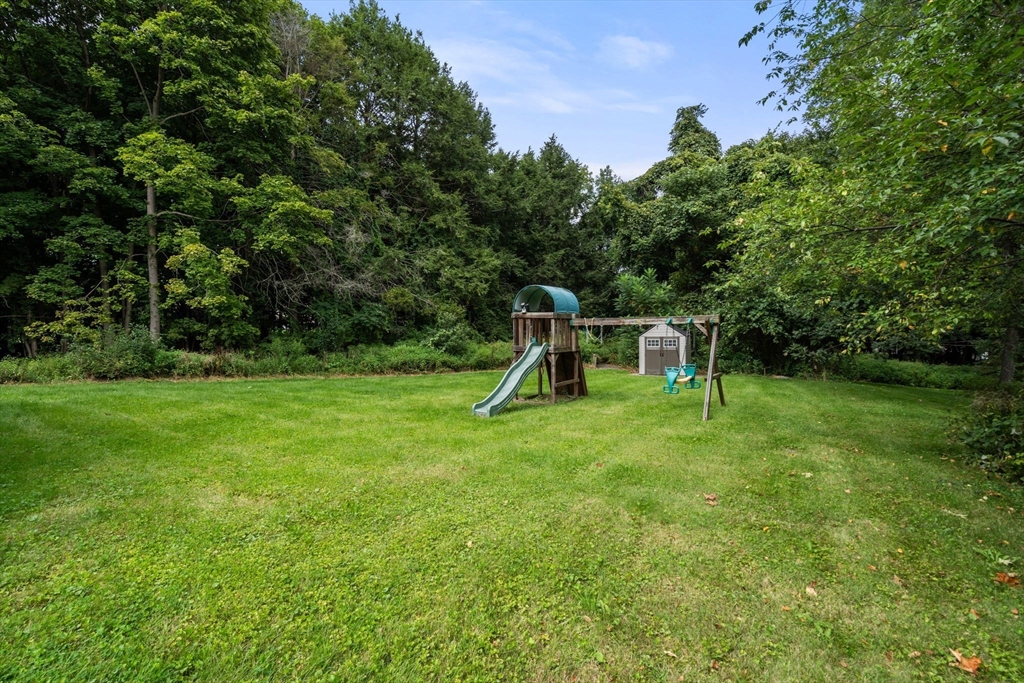 62 Nelson Place Worcester, MA 01605 - Photo 29 of 33 a view of a backyard with a slide trees and wooden fence