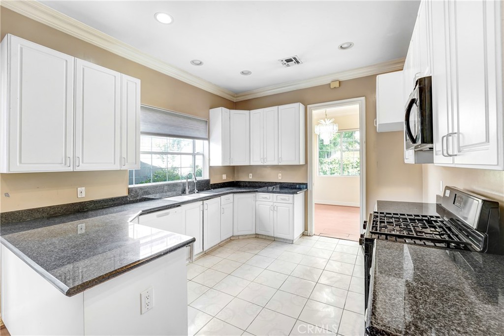 17919 Califa Street Encino, CA 91316 - Photo 3 of 11 a kitchen with a sink a stove and cabinets