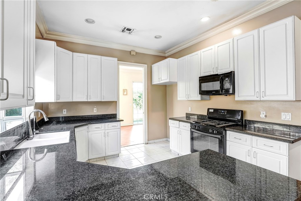17919 Califa Street Encino, CA 91316 - Photo 4 of 11 a kitchen with granite countertop a stove sink and cabinets