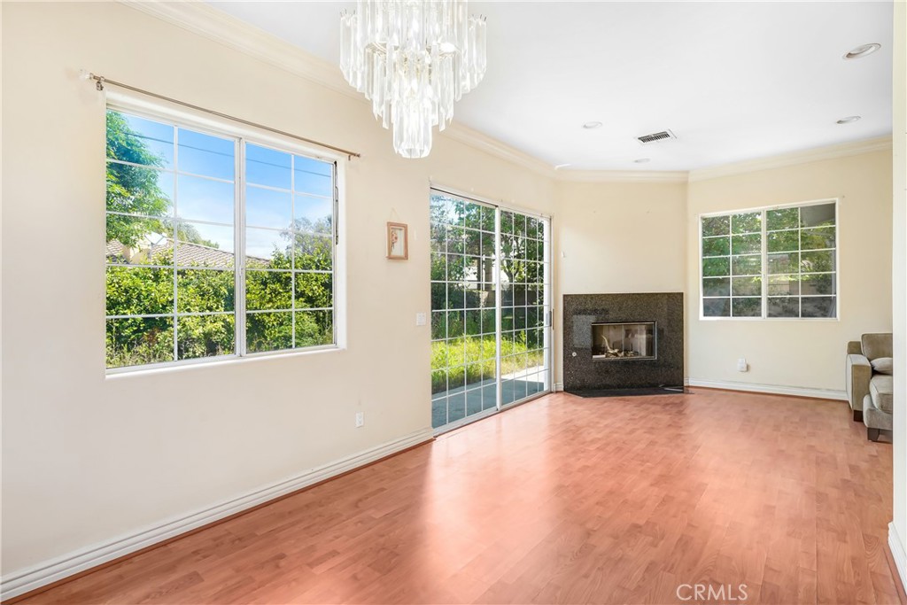 17919 Califa Street Encino, CA 91316 - Photo 7 of 11 a view of empty room with wooden floor and fireplace