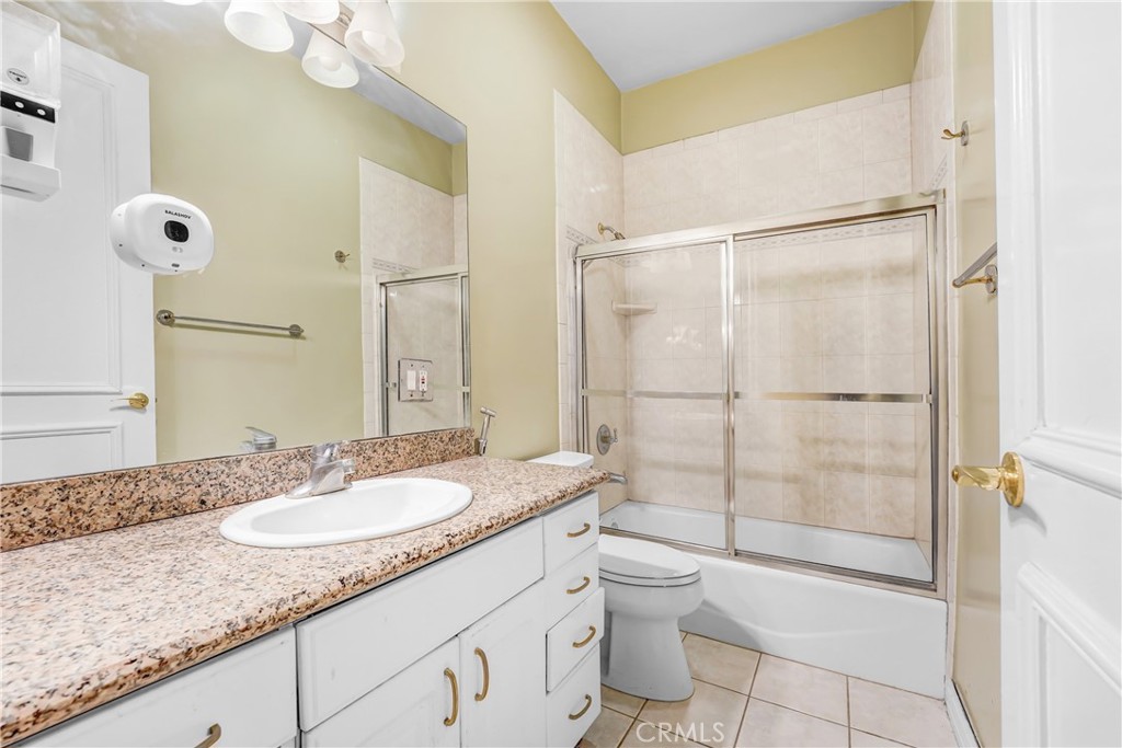 17919 Califa Street Encino, CA 91316 - Photo 10 of 11 a bathroom with a granite countertop sink a toilet and shower