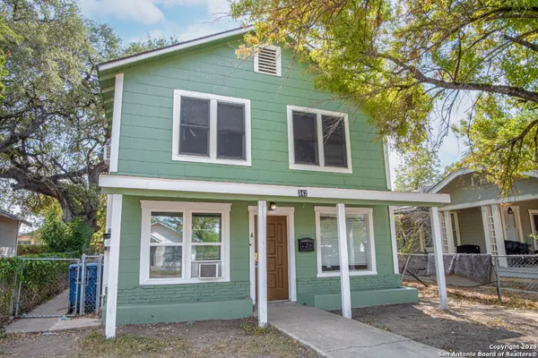 front view of a brick house with a small yard