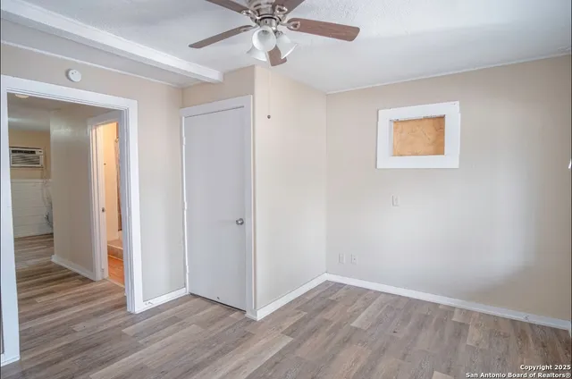 a view of an empty room with wooden floor